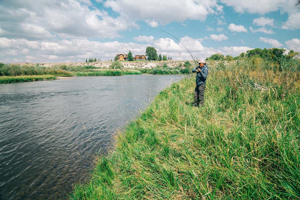 north platte river fisherman standing on grass while holding fishing rod outdoors